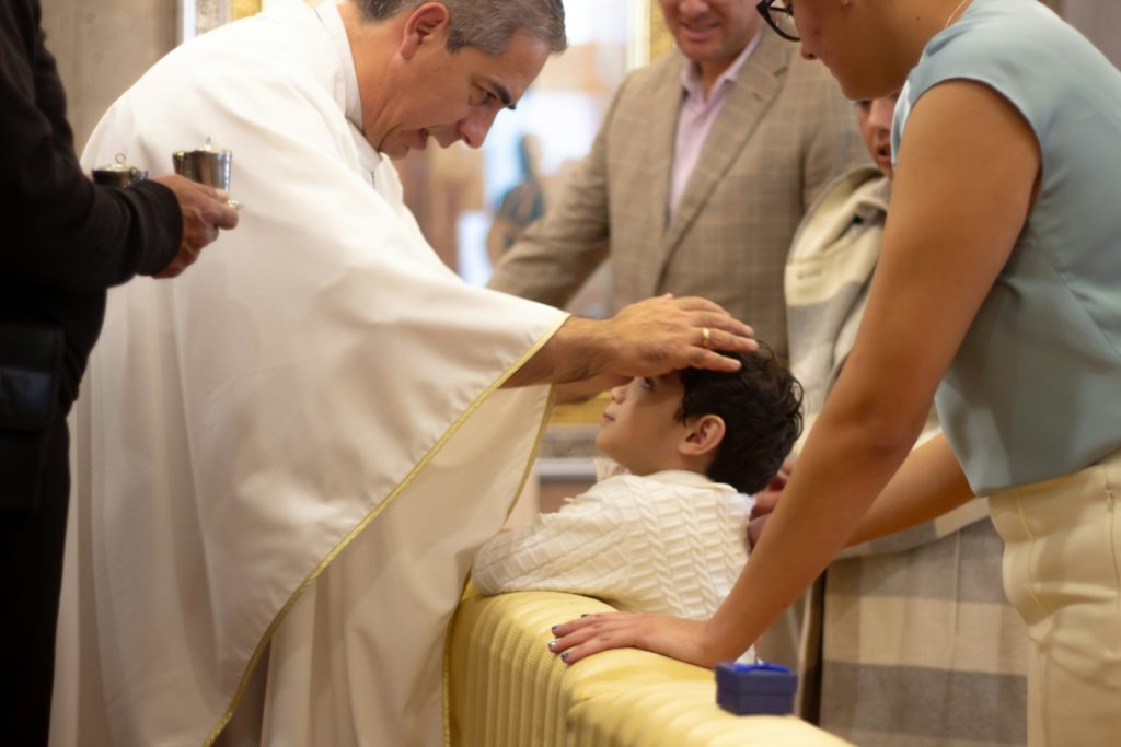 A group of people standing around a man in a priest's robes